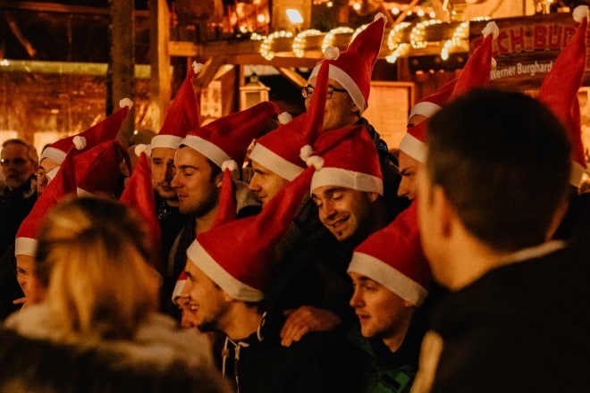 group of people with santa hats on - christmas party games