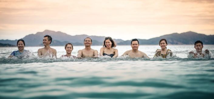 group of people with half of their bodies immersed in the water