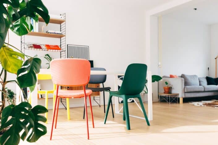 an empty room with colorful chairs and table
