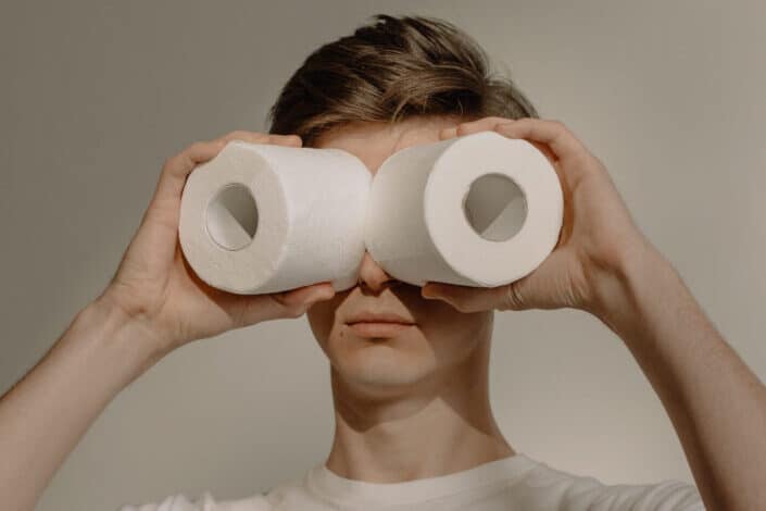 man using toilet paper rolls as binoculars