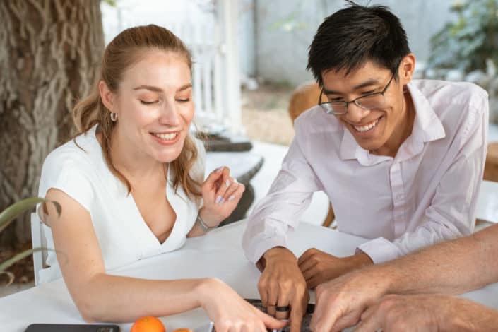 man and woman both wearing white pointing at something on a table