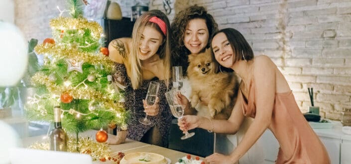 three women and a dog smiling