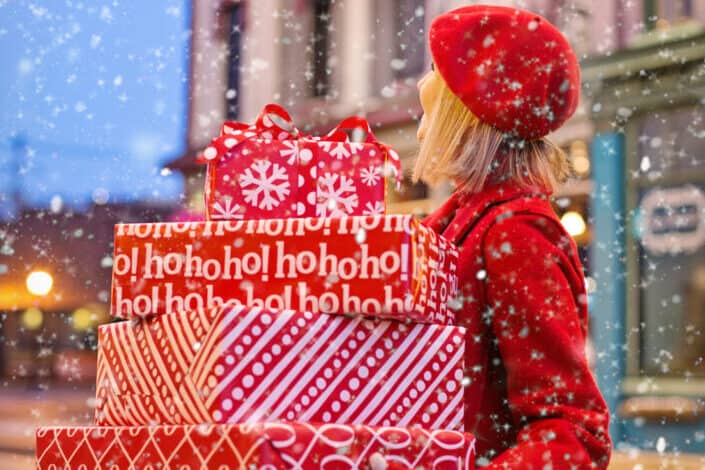 woman holding a lot of gifts while enjoying the snow