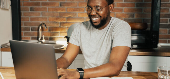 guy smiling in front of laptop