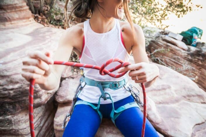 a smiling woman fixing her harness