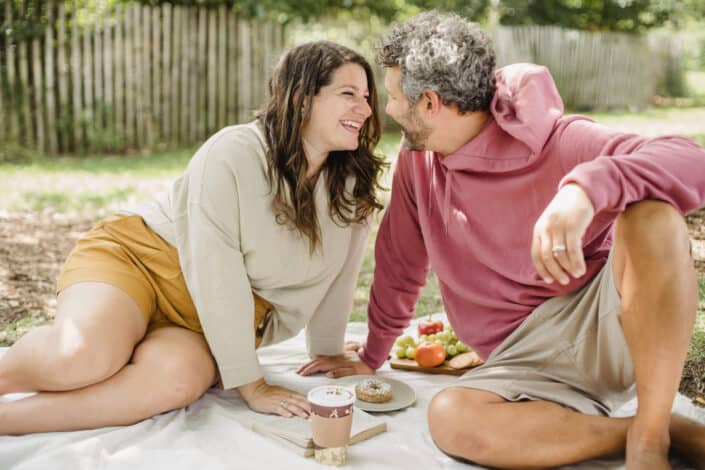 couple having a picnic and smiling at each other