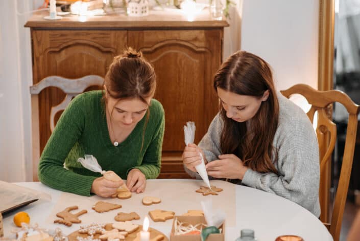 two women decorating christmas cookies 