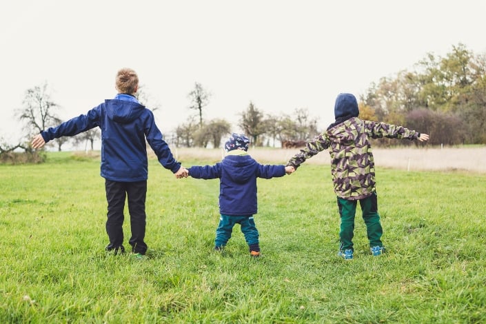three kids holding hands