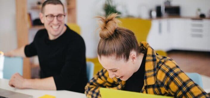 man and woman laughing inside their office