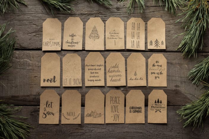 Collection of christmas tags placed on wooden surface