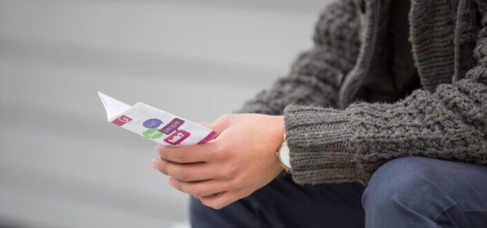 Person in sweater holding a card 