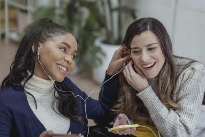 friends smiling and listening to music together