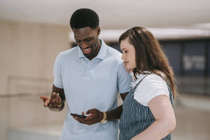 Man and woman looking at a message over the guy's phone