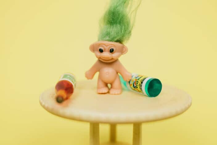 Mini troll toy on table with bottles