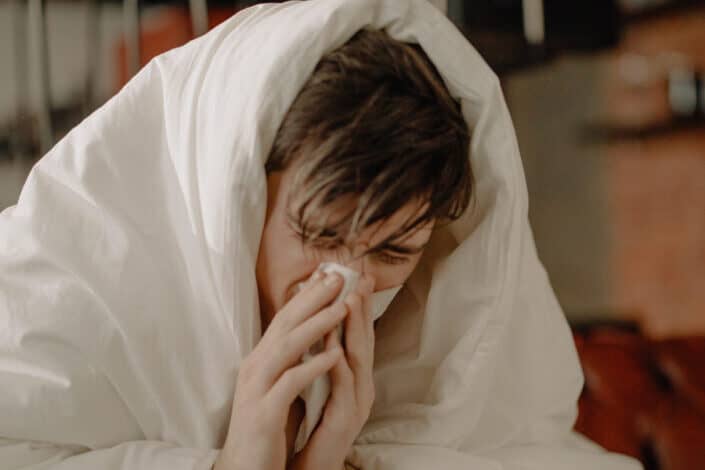 Sick Man Wiping His Nose with Tissue