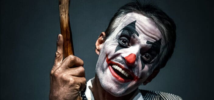 Man in Clown Make-up holding a Cane