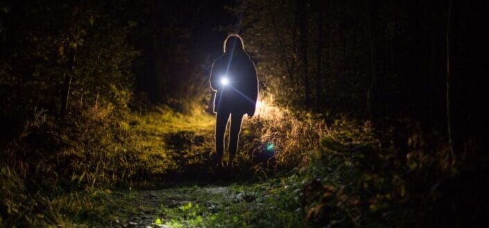 Person holding flashlight during nighttime