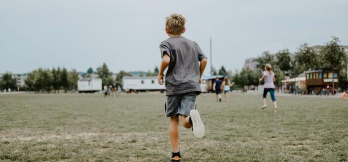 a male kid running in a field