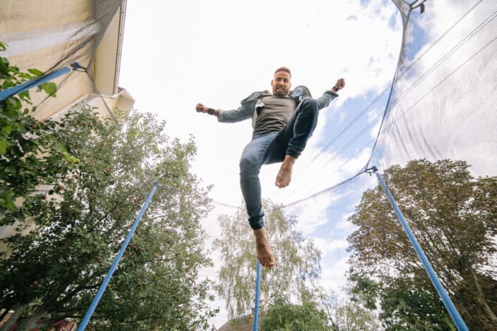 Cloudy sky above a man jumping on trampoline