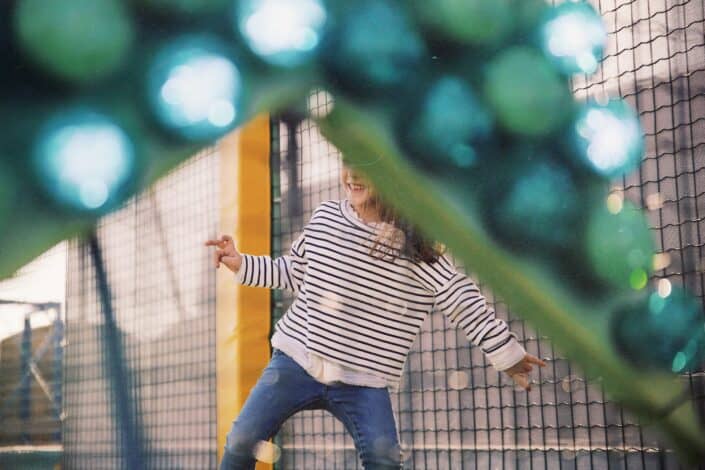 girl wearing striped shirt inside trampoline