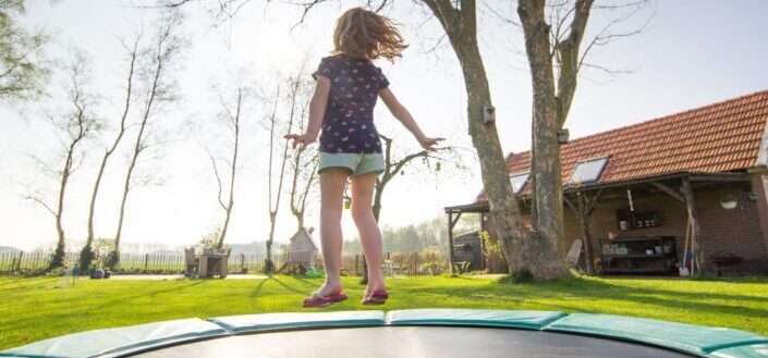 young girl playing trampoline outdoor