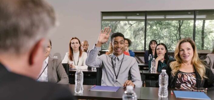 Man Raising His Hand at a Business Conference